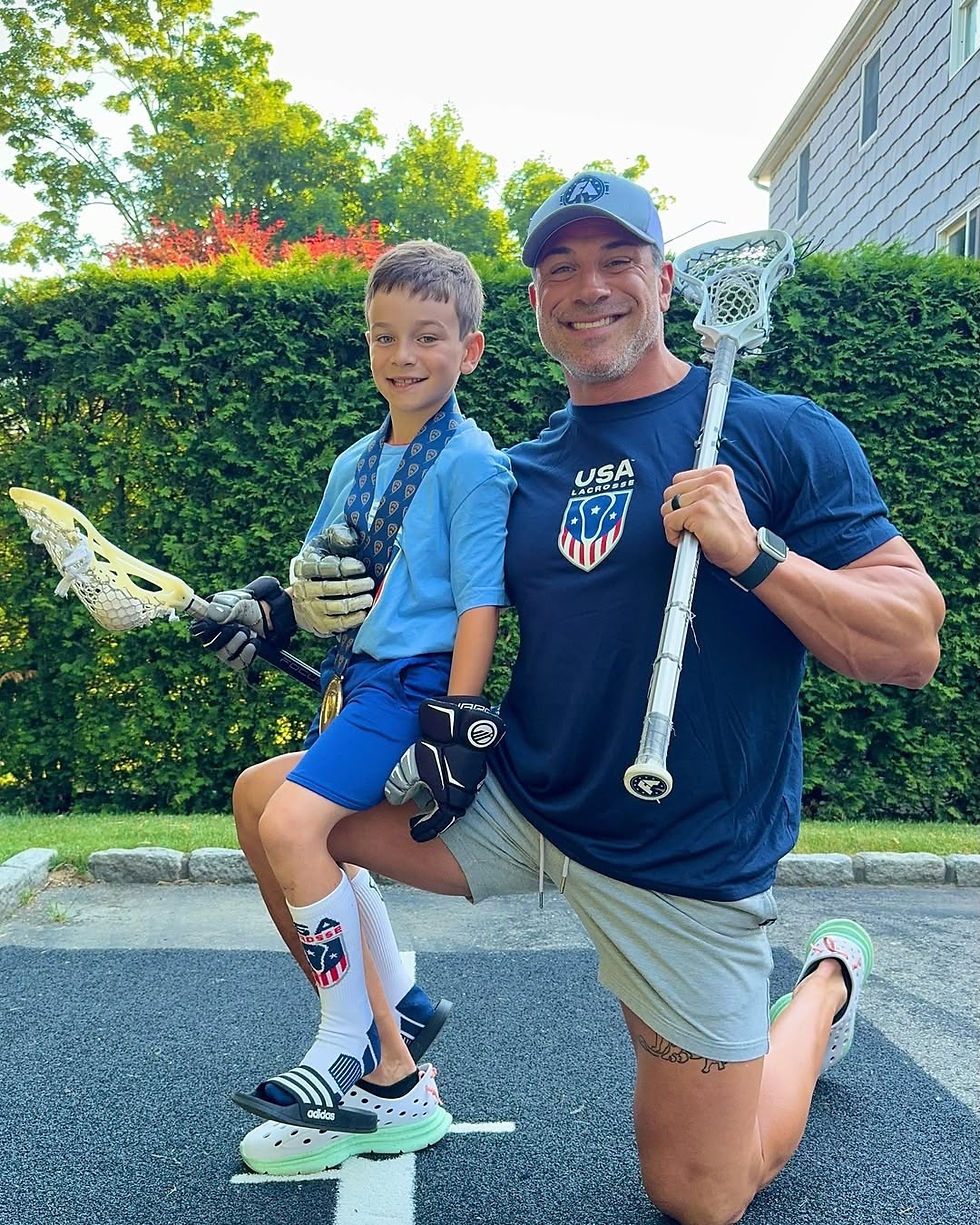 Greg and his son holding lacrosse sticks