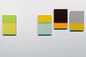 Two paintings combining yellow and pale green, and dark brown and orange, with words across the colour divisions.