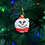 Smiling snowman Christmas ornament hanging on tree