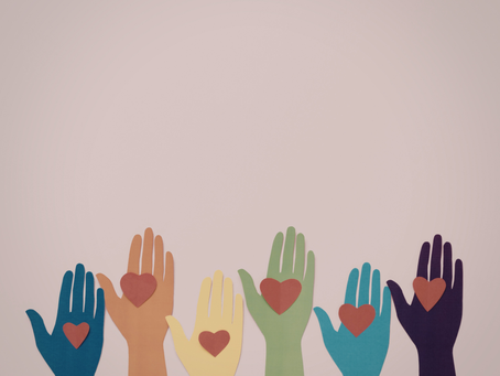 Colorful paper hands with hearts representing volunteerism, care, and community support.