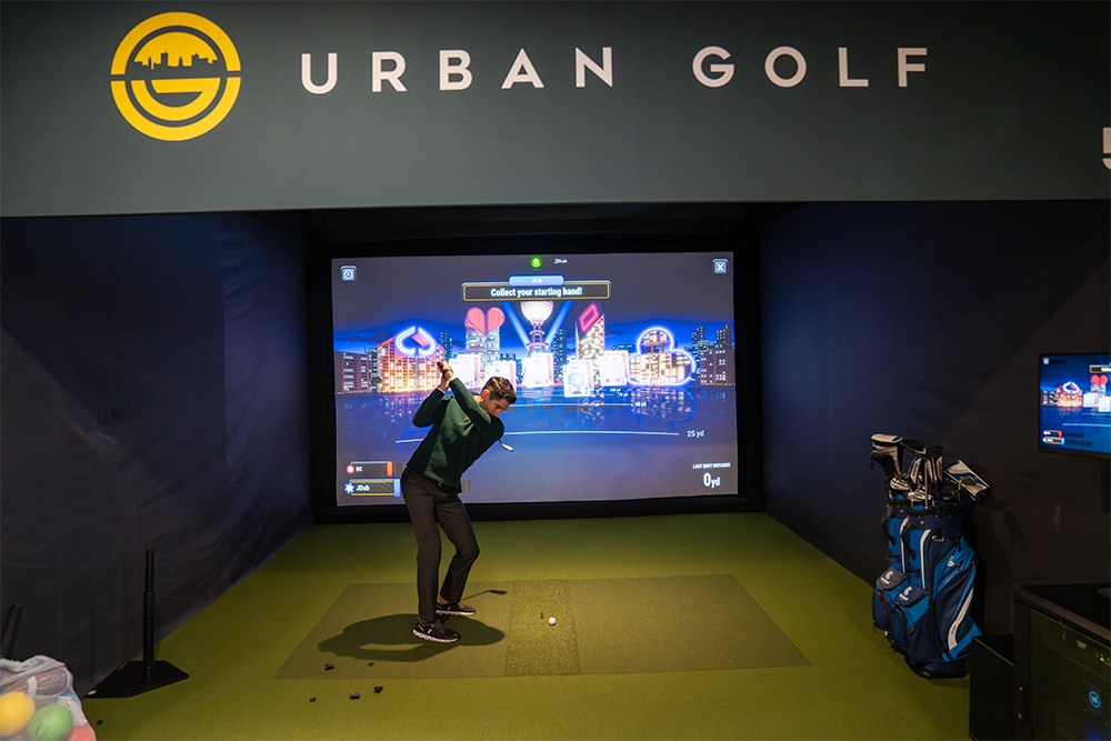 Guests playing indoor golf at Urban Golf on Floor 2
