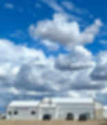 Wide Saskatchewan prairie landscape with dramatic clouds and open skies surrounding Quill Creek Farms Abattoir.