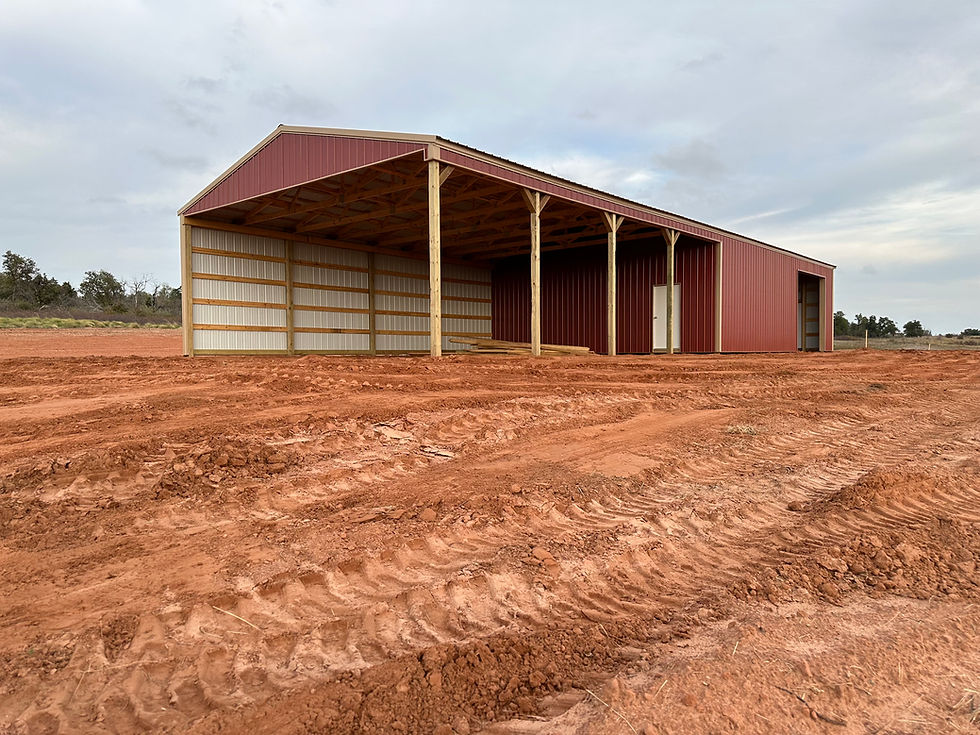 Red agricultural building with open side and extended covered equipment area
