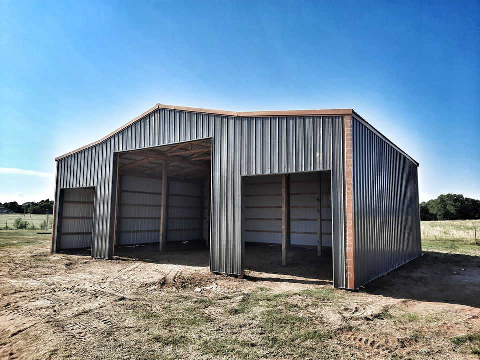 Black and brown equestrian building with three open bays