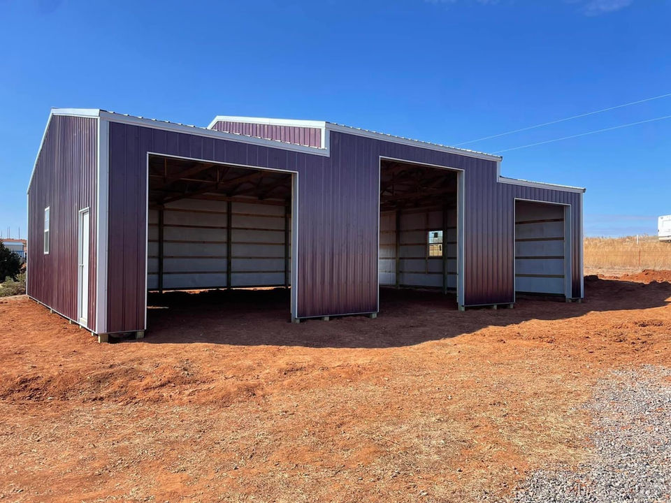 Red and white agricultural building with three open bays