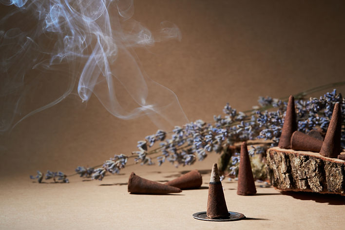 Incense cones for aromatherapy with lavender flowers on a brown background. Burning incens