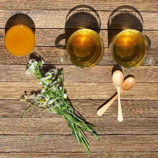 two-cups-green-tea-honey-bouquet-chamomile-wooden-spoons-table.jpeg