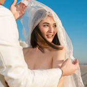 Bride under veil with beautiful blue sky