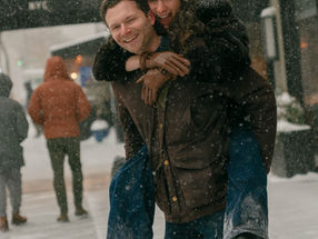 couple running through he snow in NYC