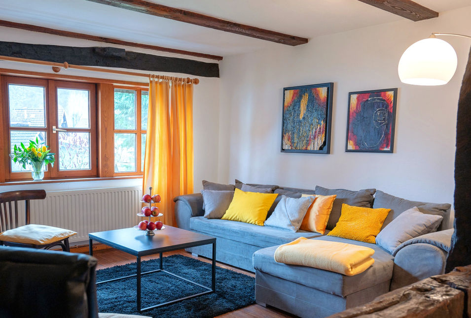 Die gemütliche Wohnlandschaft vor den Holzfenstern zum Garten.