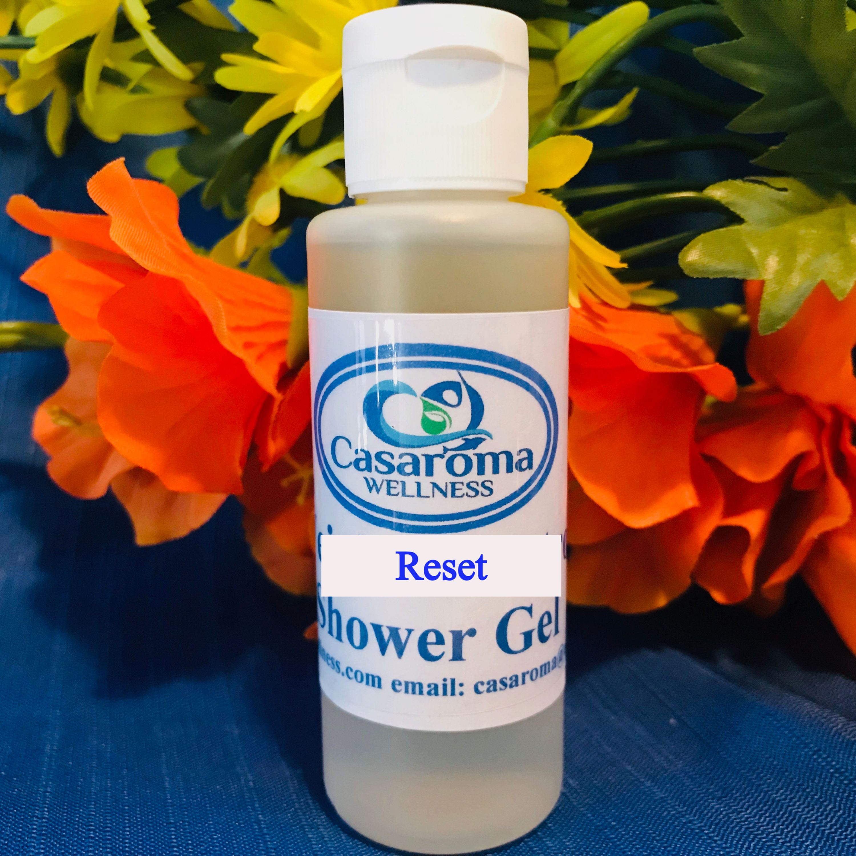 A plastic bottle with a white label saying Reset Shower Gel with the Casaroma Logo