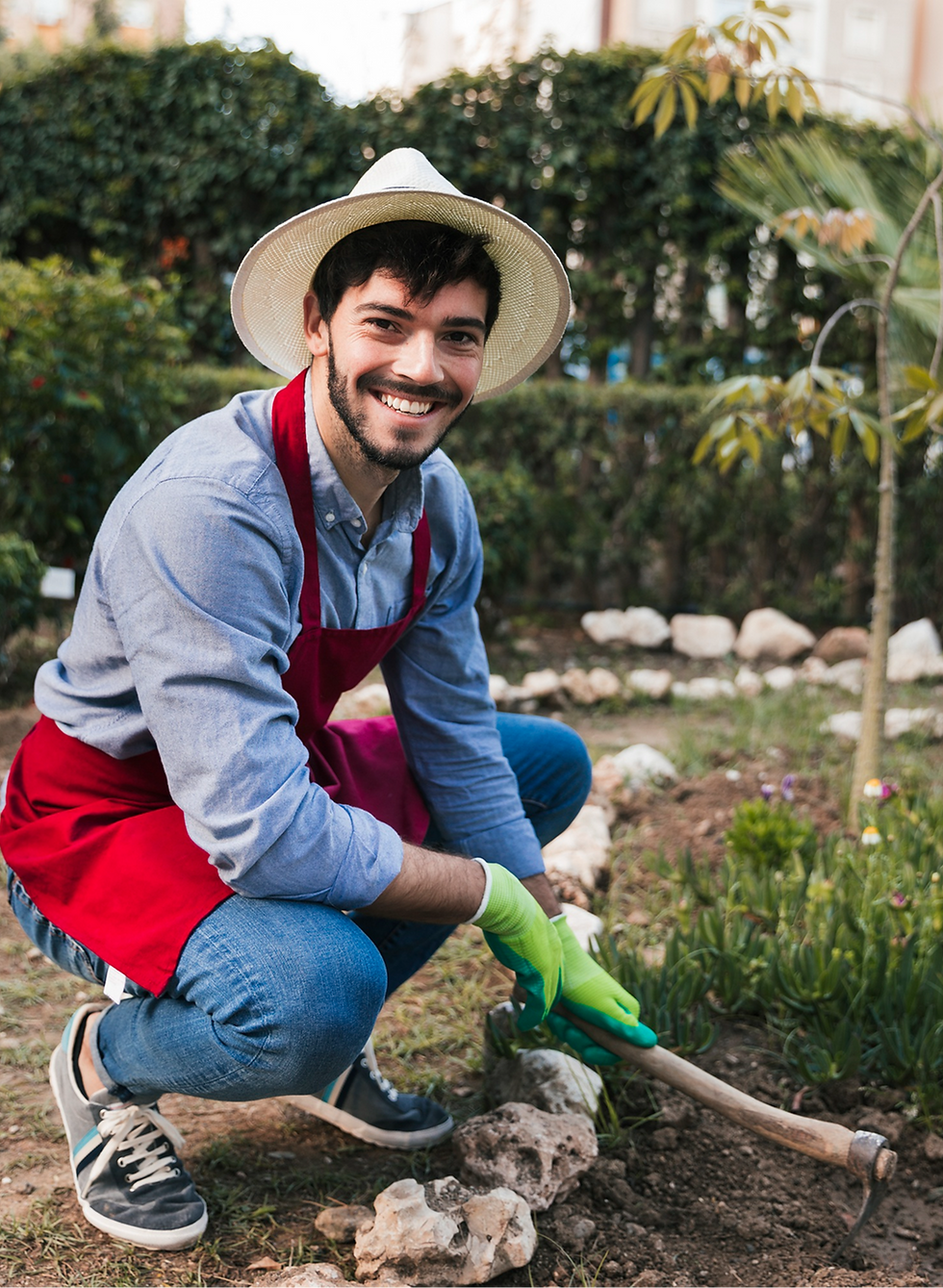 Smiling gardener wearing hat and apron, working in garden near plants.