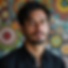 Man with beard looks at camera with colorful artwork background Theme 40