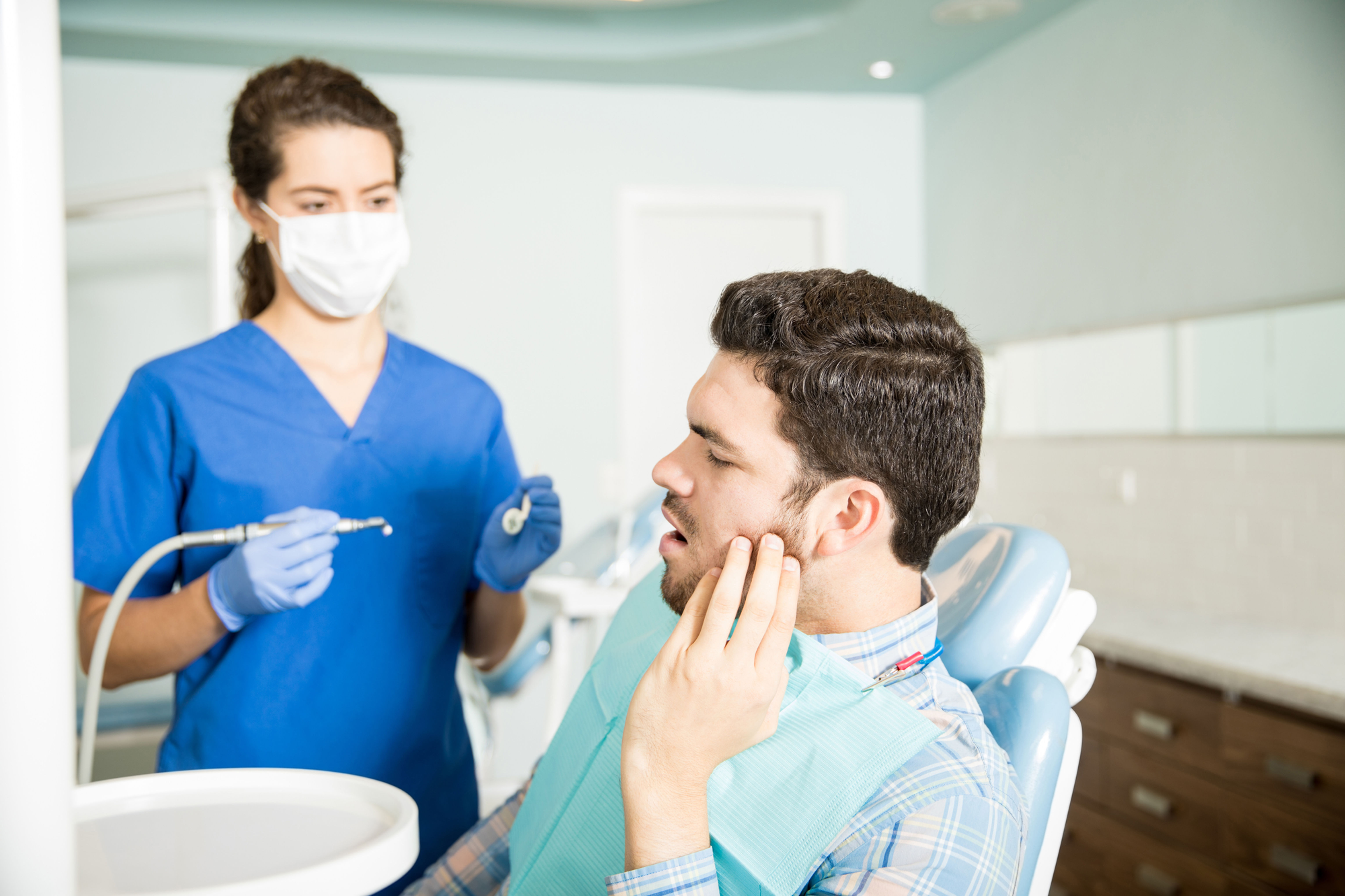 Dental professional with patient holding jaw