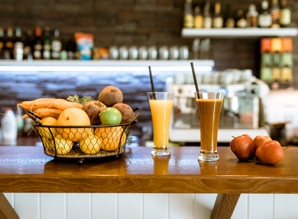 Fresh fruit and juice display on bar with two full glasses and Home