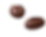 Two chocolate-covered coffee beans on a solid black background