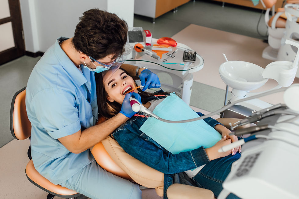 Dentist examining smiling patient's teeth