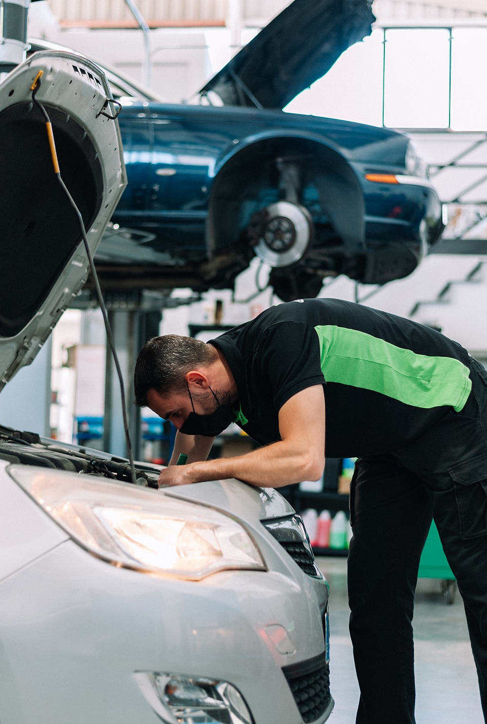 Mechanic repairs a car engine in auto repair shop for service.