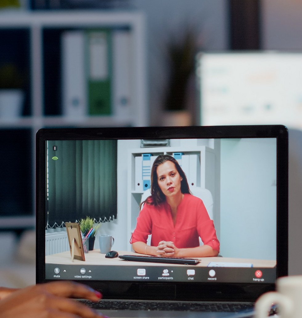 Woman on laptop video call in office, red shirt, professional meeting.