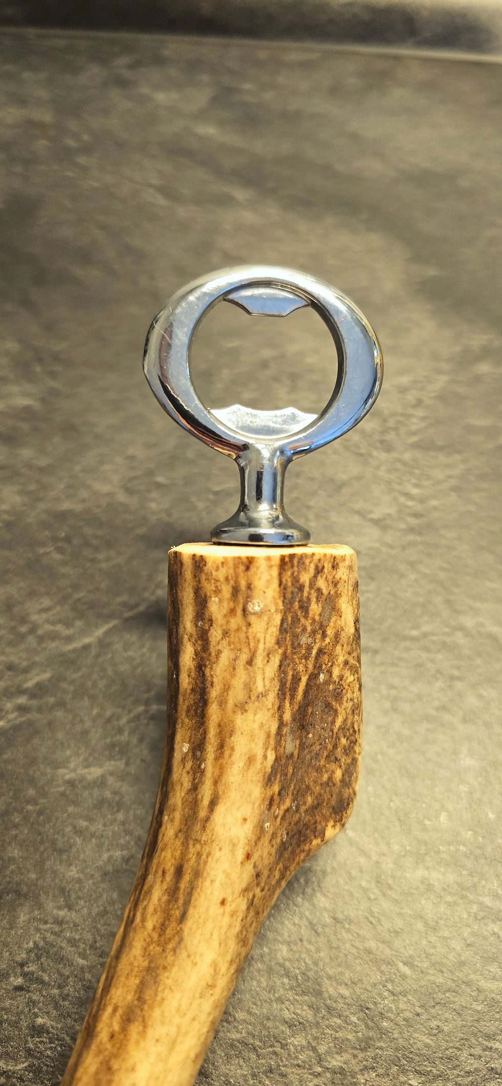 Miniaturbild: Massiver Flaschenöffner aus Hirschgeweih, handgearbeitet mit ergonomischer Form und charakteristischer Oberflächenstruktur.
