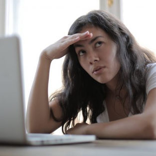 Woman at laptop looking stressed