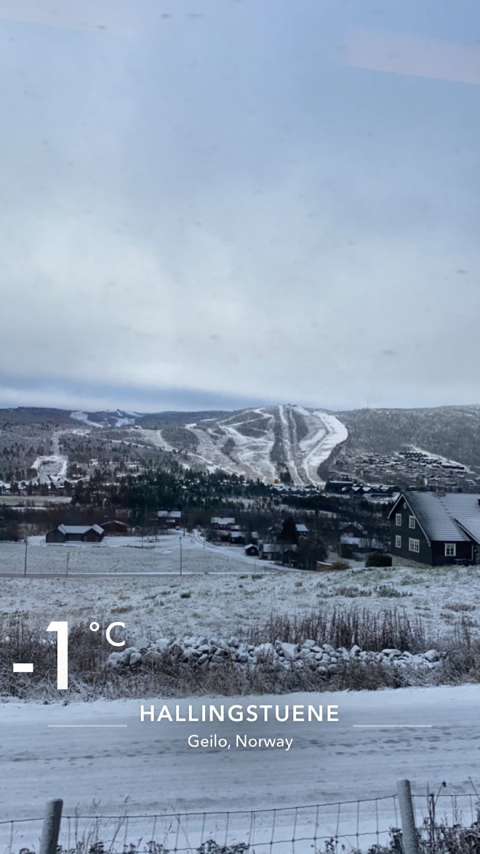 Snow-covered landscape with ski slopes, a dark house in the foreground, cloudy sky, and temperature reading -1°C. Text: Hallingstuene, Geilo, Norway.
