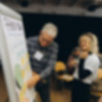 Zwei Personen stehen vor einem Flipchart und arbeiten gemeinsam