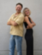 Zwei Personen stehen Rücken an Rücken und lachen