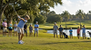 Junior golfer competing in a youth golf tournament while parents and fellow players watch 