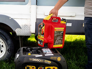 a person filling up a generator with gasoline using a surecan gas can