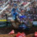 Max racing his dirt bike at supercross