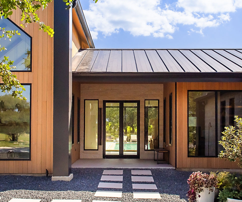 Modern custom house exterior with wood siding, glass doors, and entrance.