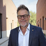Smiling man with glasses, beard, and blazer
