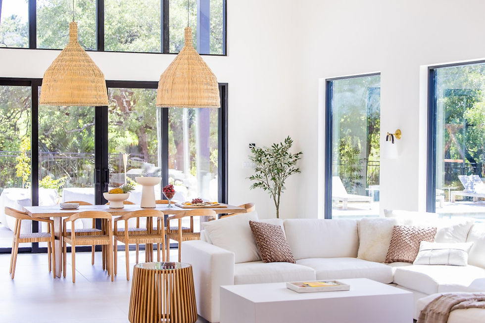 Modern open-plan living room with white sofa and wooden dining table.