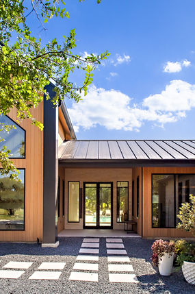 Sleek modern house, wood facade, large windows, inviting glass double doors.