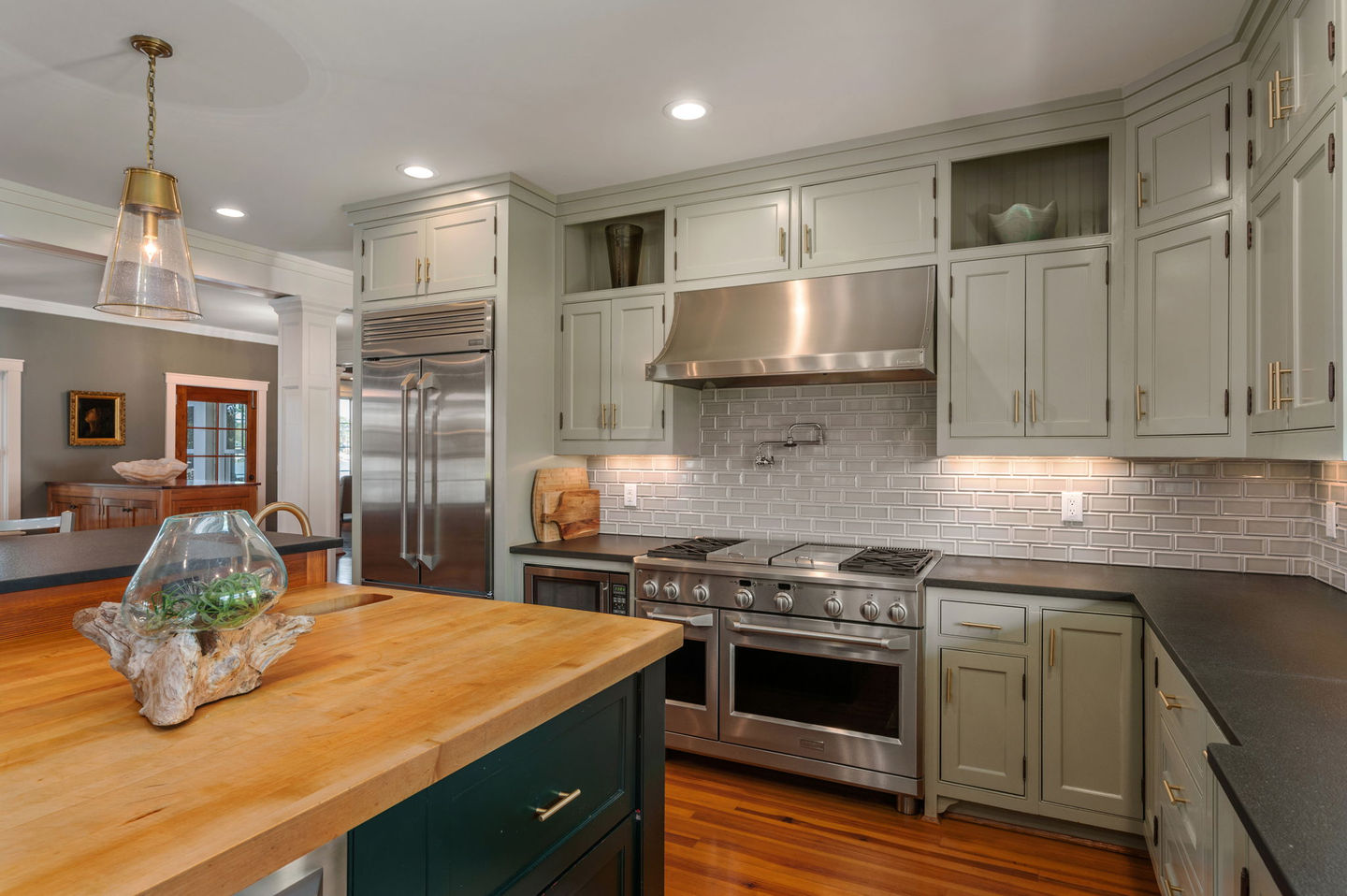 a kitchen with stainless steel appliances and green cabinets