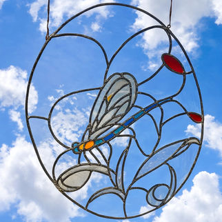 Vitrail circulaire suspendu représentant une libellule aux ailes translucides sur fond de ciel bleu, technique plomb et verre