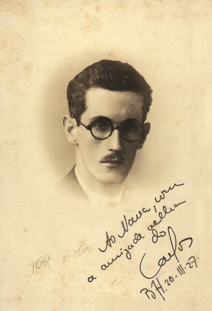 Retrato em preto e branco de um homem com óculos e cabelo bem penteado, acompanhado de uma dedicatória manuscrita.