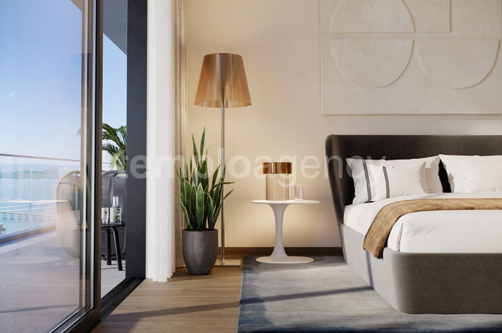 Dormitorio con acceso a una terraza privada y vistas al agua.