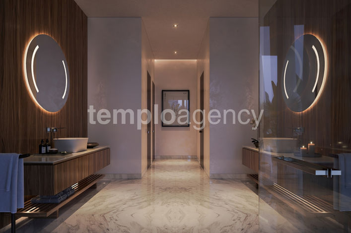 Baño con lavabos dobles, acabados de madera y espejos iluminados.
