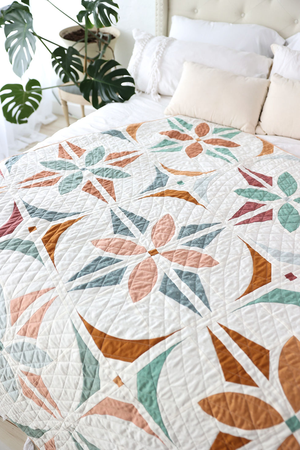 Bloom And Glow Quilt, a modern flower quilt pattern, sprawled on a bed..