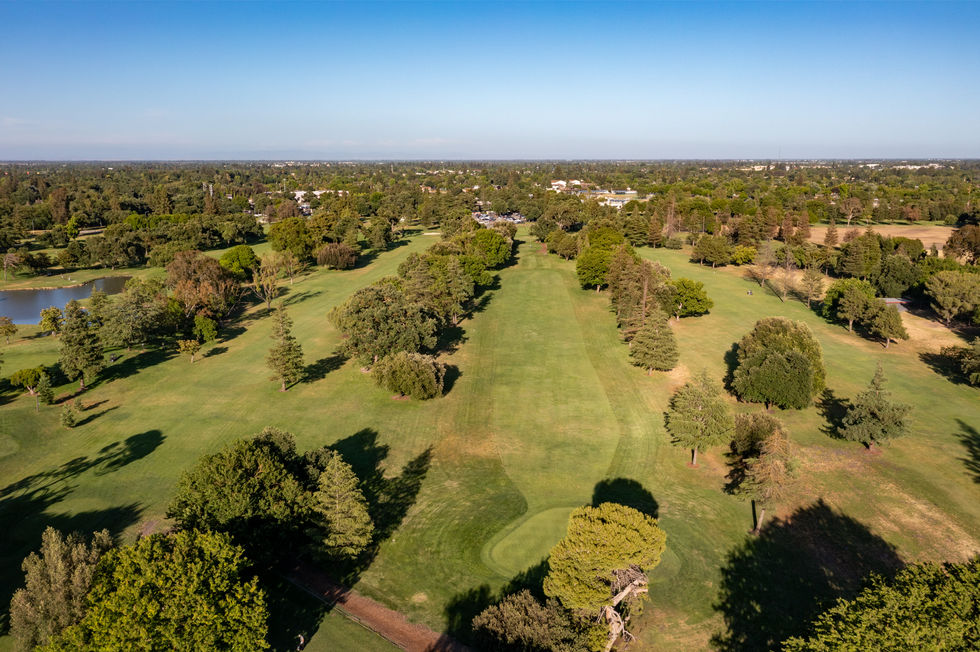 an aerial view of a golf course surrounded by trees