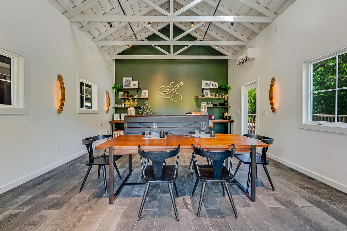 a room with a table and chairs and a green wall with the letter l on it