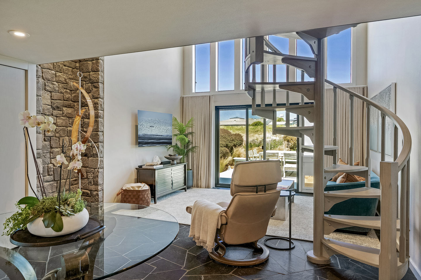 a living room with a spiral staircase and a chair