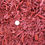 Thumbnail: image of red dyed wood chips with a quarter as size reference to the wood chip size