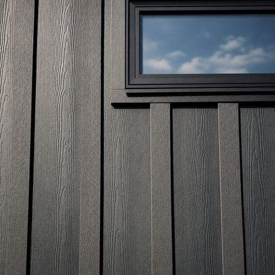 Close detail of textured black siding and black framed window at Japavarian Blades.