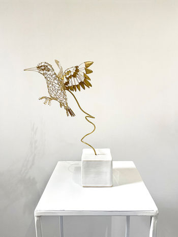 Sculpture d'un oiseau, martin pêcheur, en fil et plaques de laiton. Base en céramique émaillé blanc