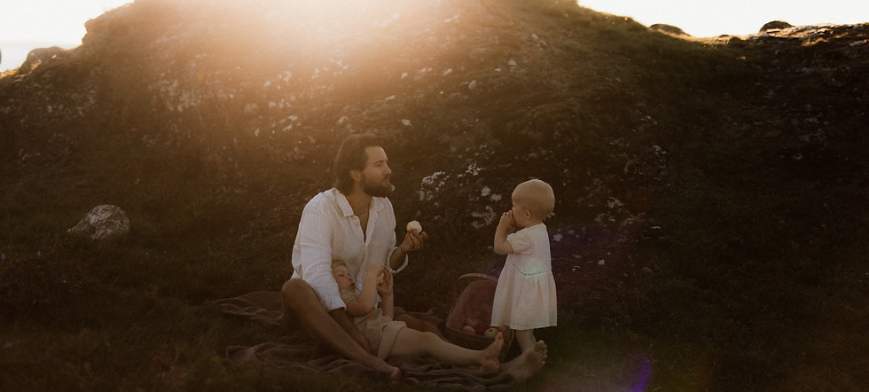 en familie på tre som spiser epler i solnedgangen
