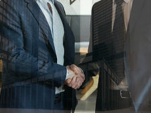 Business professionals shaking hands, representing strategic partnership development and sourcing solutions for industrial companies