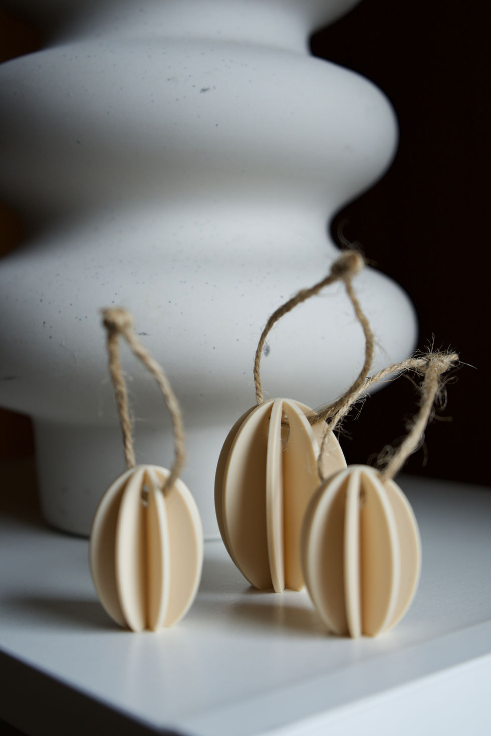 Minimalistische Osterdeko mit hängenden Ostereiern in Beige an Zweigen